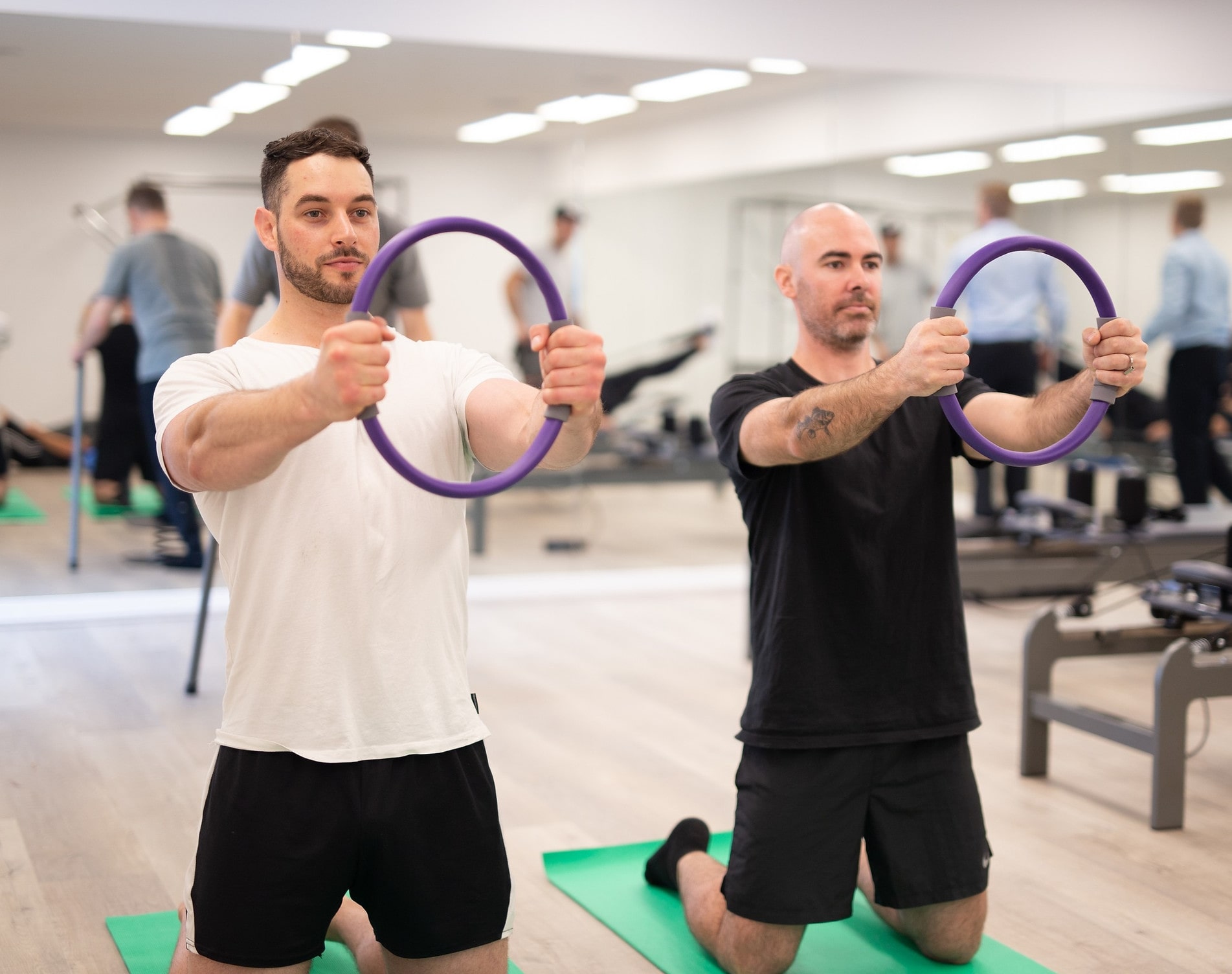 A group of people engaged in physiotherapy exercises in a bright, modern clinic in Adelaide.