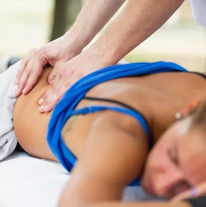 Image of a woman receiving a back massage from a massage therapist.