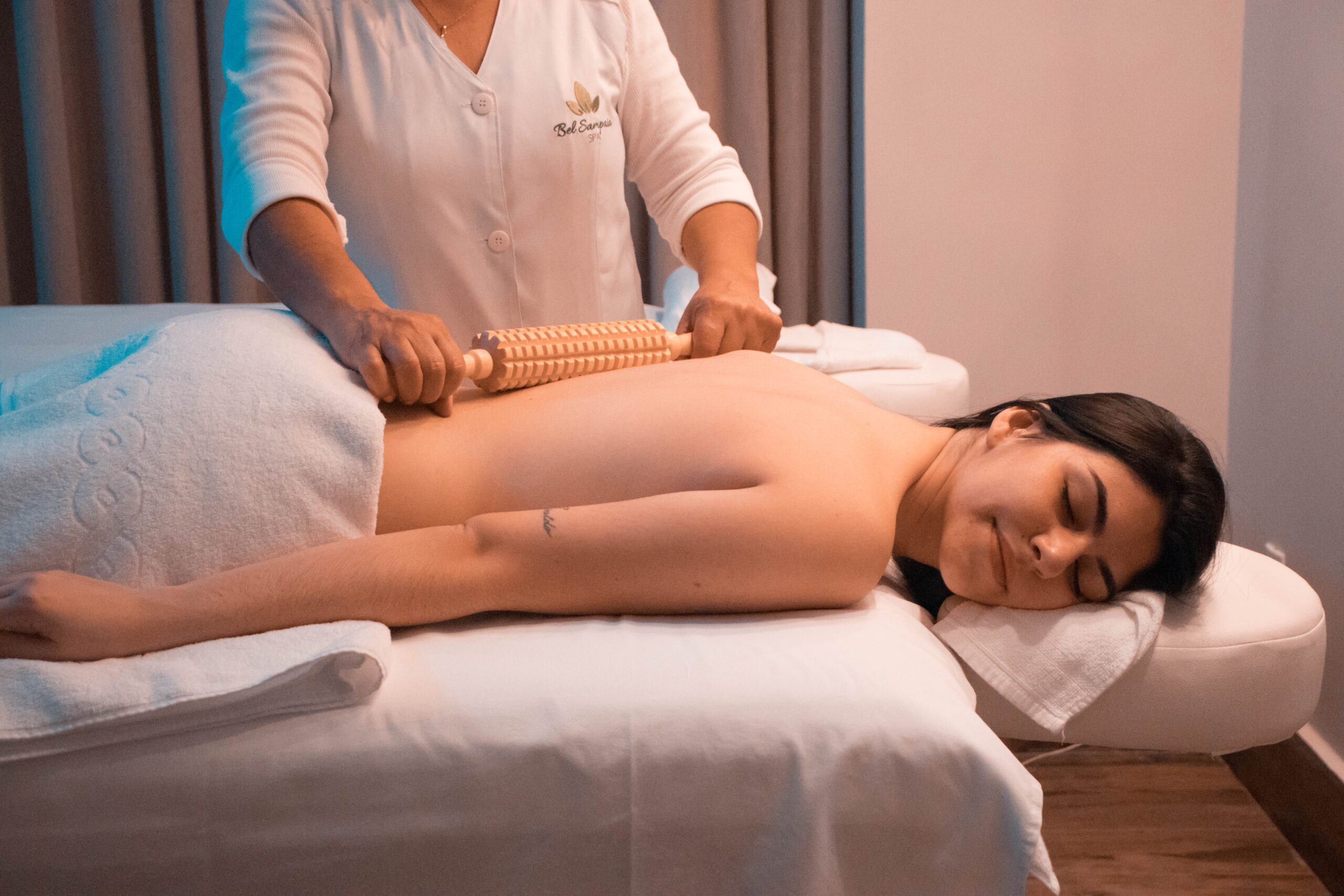 A woman receiving remedial massage on her back from a massage therapist.