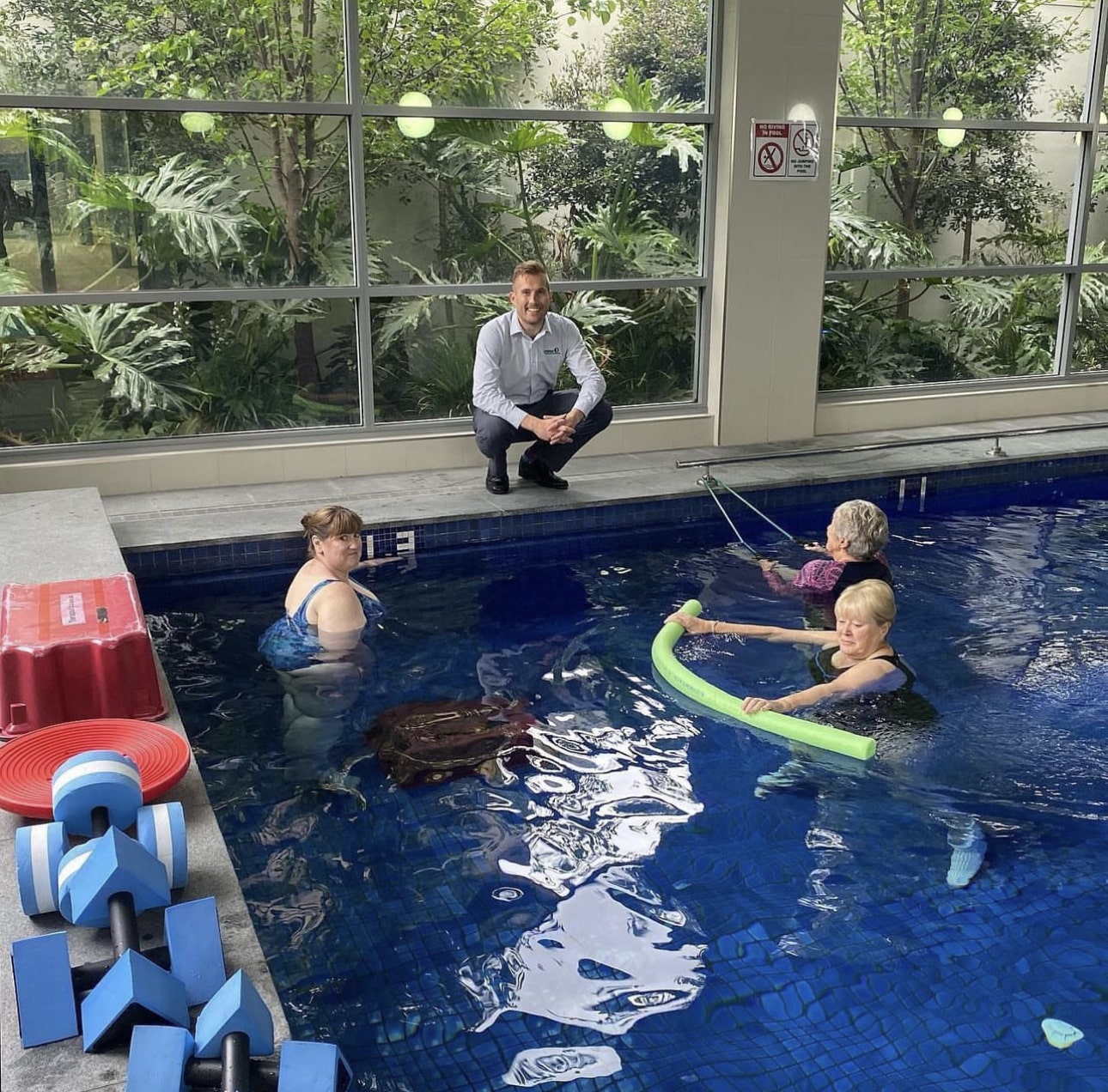 A group of individuals undergoing hydrotherapy treatment in a pool under the supervision of a physiotherapist at Yates Physiotherapy, Adelaide